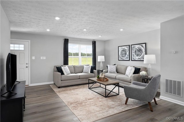 living room with hardwood / wood-style flooring and a textured ceiling