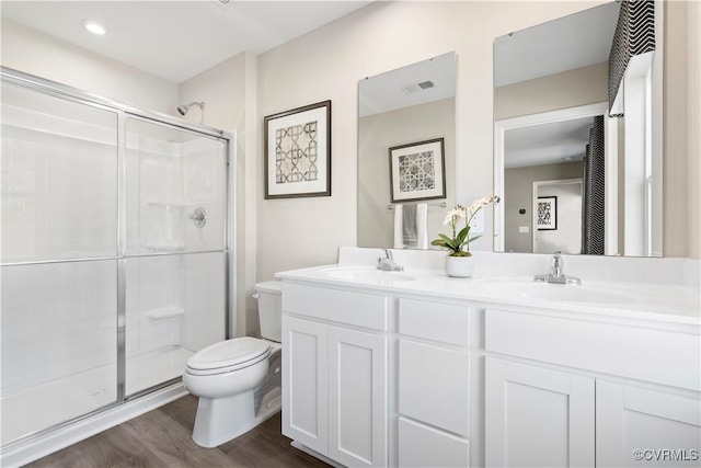 bathroom featuring vanity, toilet, an enclosed shower, and hardwood / wood-style floors