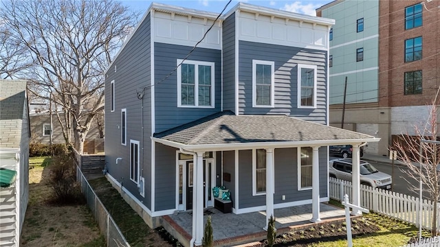 exterior space featuring a porch, roof with shingles, and fence