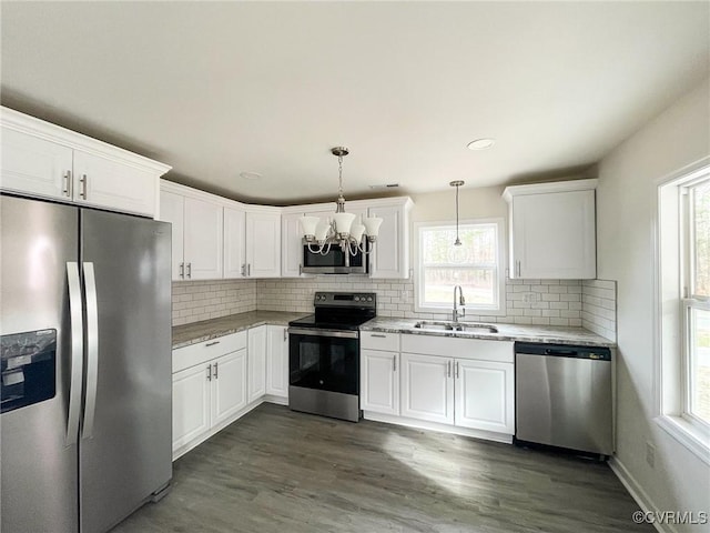 kitchen featuring pendant lighting, sink, white cabinets, stainless steel appliances, and light stone countertops