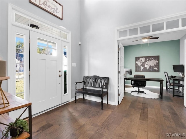 foyer entrance with a towering ceiling, dark hardwood / wood-style floors, and ceiling fan