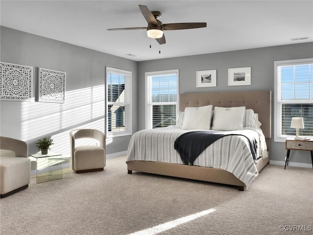 bedroom featuring ceiling fan, multiple windows, and carpet