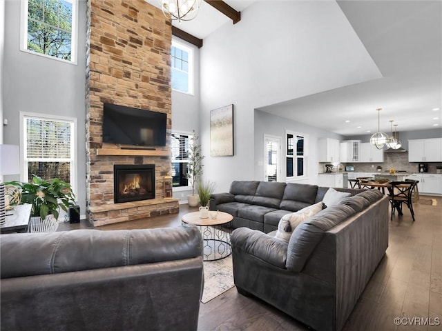 living room with beamed ceiling, a high ceiling, dark hardwood / wood-style floors, and a fireplace