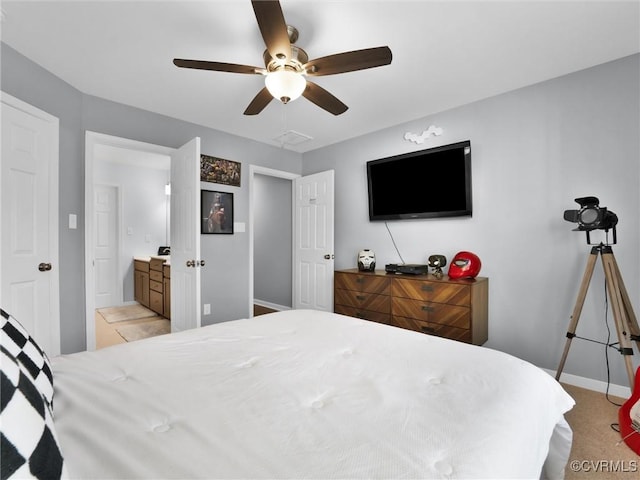 carpeted bedroom featuring ceiling fan and ensuite bath