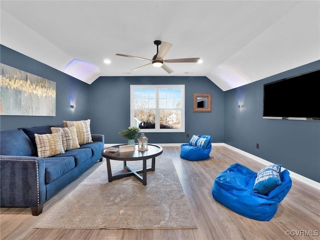 living room featuring lofted ceiling, ceiling fan, and light wood-type flooring