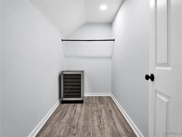 walk in closet featuring vaulted ceiling, light hardwood / wood-style floors, and beverage cooler