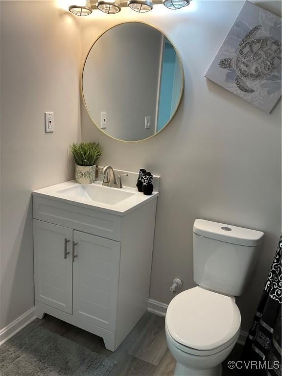 bathroom with vanity, wood-type flooring, and toilet