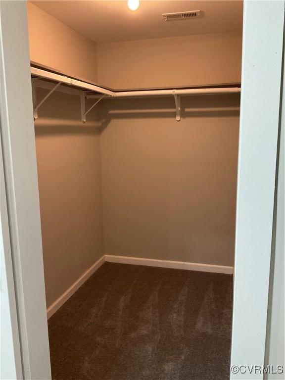 spacious closet featuring dark carpet