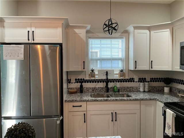 kitchen with sink, white cabinets, hanging light fixtures, stainless steel appliances, and light stone countertops