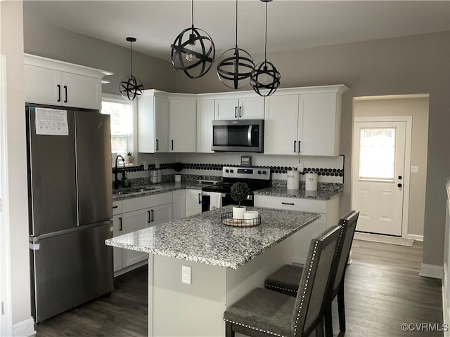 kitchen featuring pendant lighting, stainless steel appliances, sink, and white cabinets