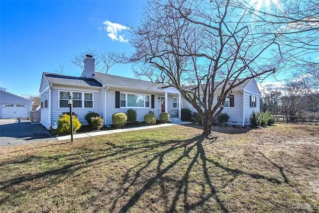 single story home with a garage, an outdoor structure, and a front lawn