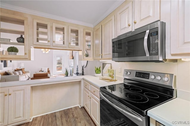 kitchen with hardwood / wood-style flooring, appliances with stainless steel finishes, and crown molding