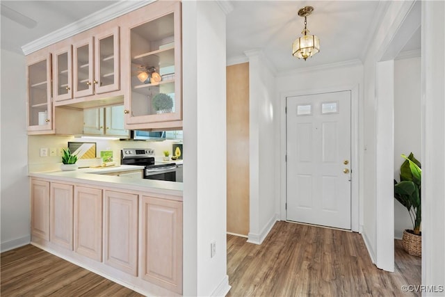 foyer featuring a notable chandelier, wood-type flooring, and ornamental molding