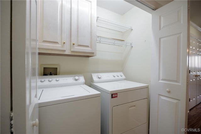 washroom featuring cabinets and washer and clothes dryer