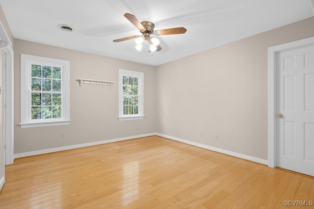 spare room with ceiling fan, plenty of natural light, and light wood-type flooring