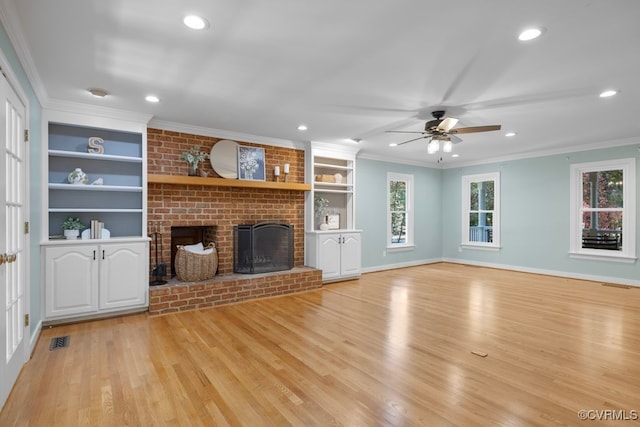 unfurnished living room featuring ornamental molding, a brick fireplace, light hardwood / wood-style flooring, and built in shelves