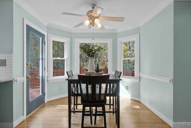 dining room featuring ornamental molding, light hardwood / wood-style floors, and plenty of natural light