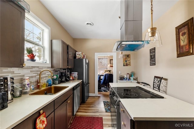 kitchen featuring sink, dark brown cabinets, appliances with stainless steel finishes, pendant lighting, and decorative backsplash