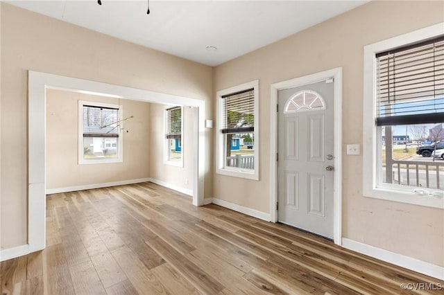 foyer with baseboards and wood finished floors