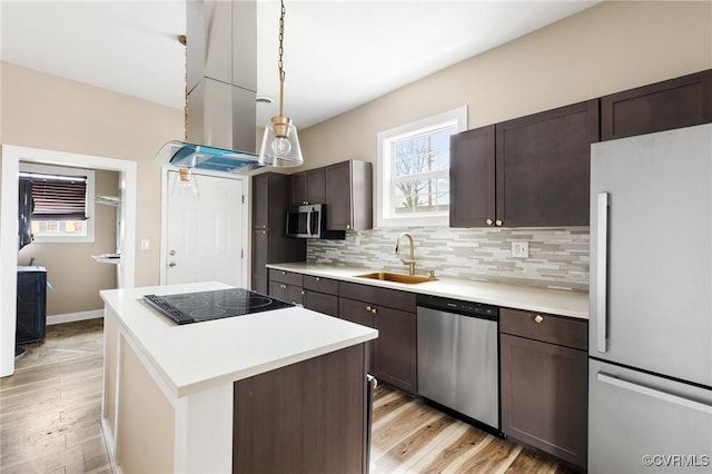 kitchen with appliances with stainless steel finishes, a sink, dark brown cabinetry, and tasteful backsplash