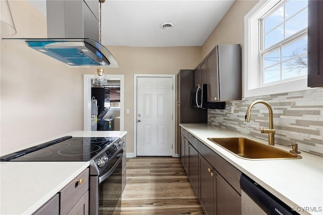 kitchen featuring light countertops, visible vents, decorative backsplash, appliances with stainless steel finishes, and a sink