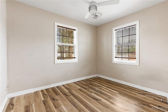 spare room featuring ceiling fan, baseboards, and wood finished floors