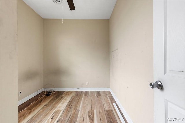 spare room with a ceiling fan, light wood-style flooring, and baseboards