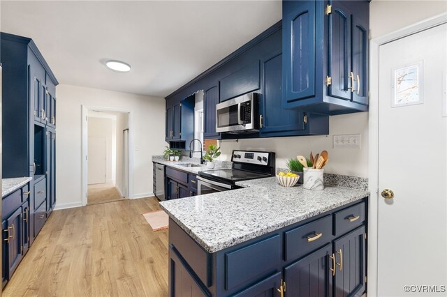 1100 N Ave, Hopewell, VA 23860 - kitchen featuring appliances with stainless steel finishes, a sink, blue cabinets, light wood-type flooring, and light stone counters