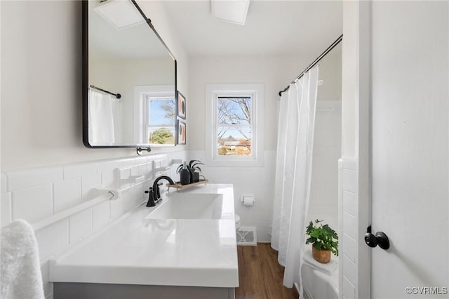 bathroom with vanity, hardwood / wood-style floors, and tile walls