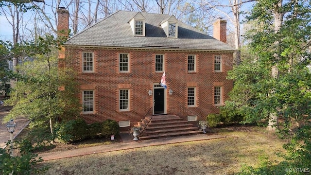 view of front of home featuring a high end roof, crawl space, brick siding, and a chimney