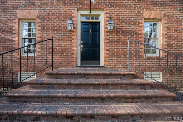 doorway to property with brick siding