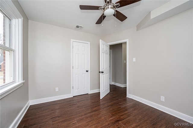 unfurnished bedroom with ceiling fan, dark hardwood / wood-style flooring, and a closet