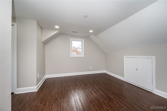 additional living space with vaulted ceiling and dark hardwood / wood-style floors