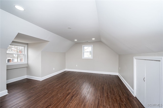 bonus room with dark hardwood / wood-style floors and vaulted ceiling