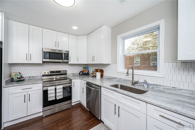 kitchen with white cabinetry, sink, stainless steel appliances, and light stone countertops