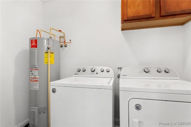 laundry area featuring cabinets, washing machine and clothes dryer, and water heater