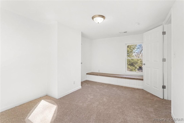 unfurnished room featuring light carpet