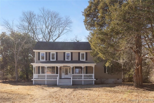 colonial home featuring a porch and a front lawn