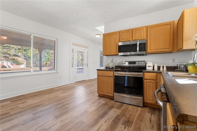 kitchen featuring sink, hardwood / wood-style flooring, a textured ceiling, and appliances with stainless steel finishes