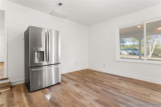 kitchen with stainless steel refrigerator with ice dispenser and hardwood / wood-style floors