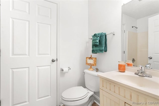 bathroom featuring vanity, walk in shower, and toilet