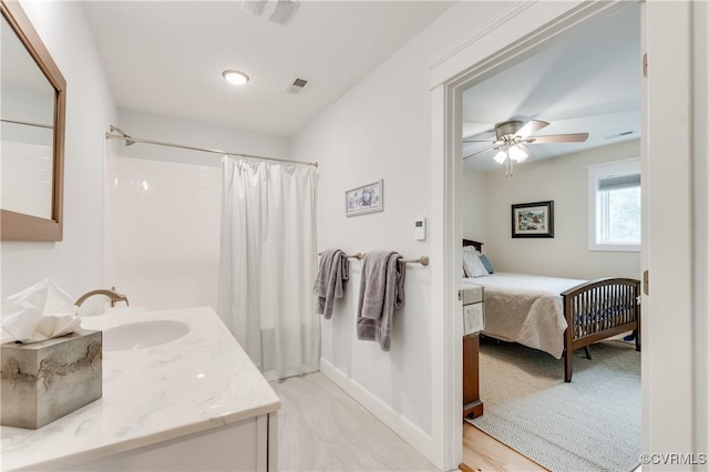 bathroom featuring vanity, ceiling fan, and walk in shower