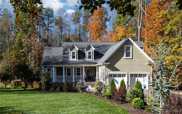 new england style home featuring a garage, a front yard, and covered porch