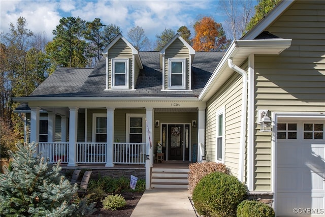 entrance to property with covered porch and a garage