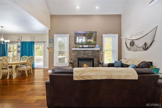 living room featuring hardwood / wood-style floors, a notable chandelier, and a fireplace