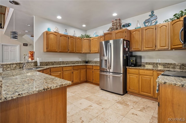 kitchen featuring sink, stainless steel appliances, light stone countertops, and kitchen peninsula