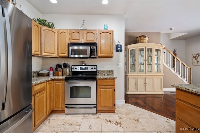 kitchen with stainless steel appliances and light stone countertops