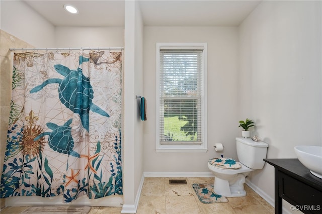 bathroom featuring toilet, vanity, a wealth of natural light, and a shower with curtain