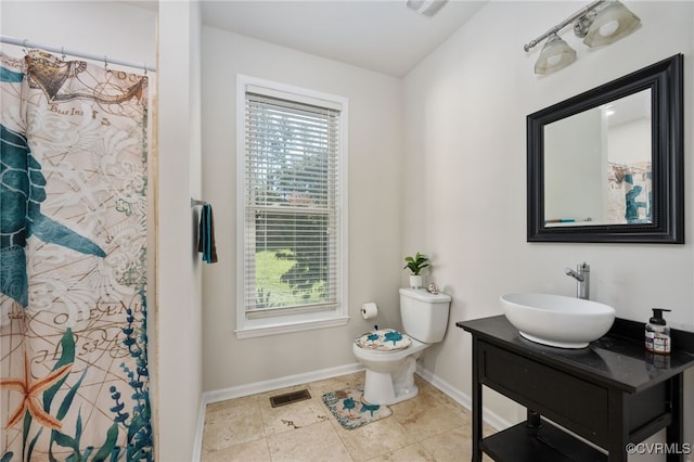 bathroom with vanity, curtained shower, and toilet