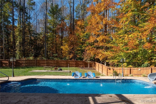 view of pool with pool water feature, a lawn, and a water slide